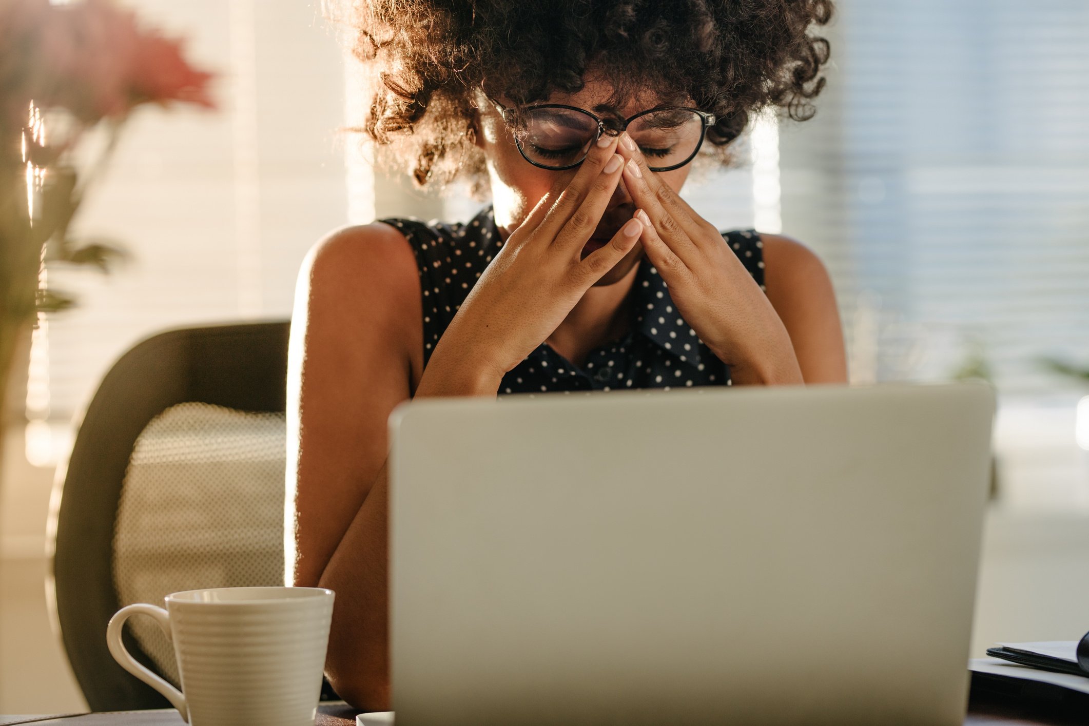 Stressed Woman at a Work Desk with a Laptop 